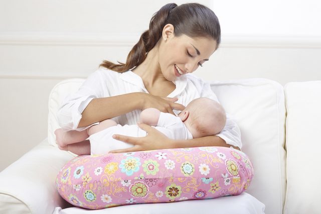 Подушка одновременно держит ребенка и поддерживает спину женщины